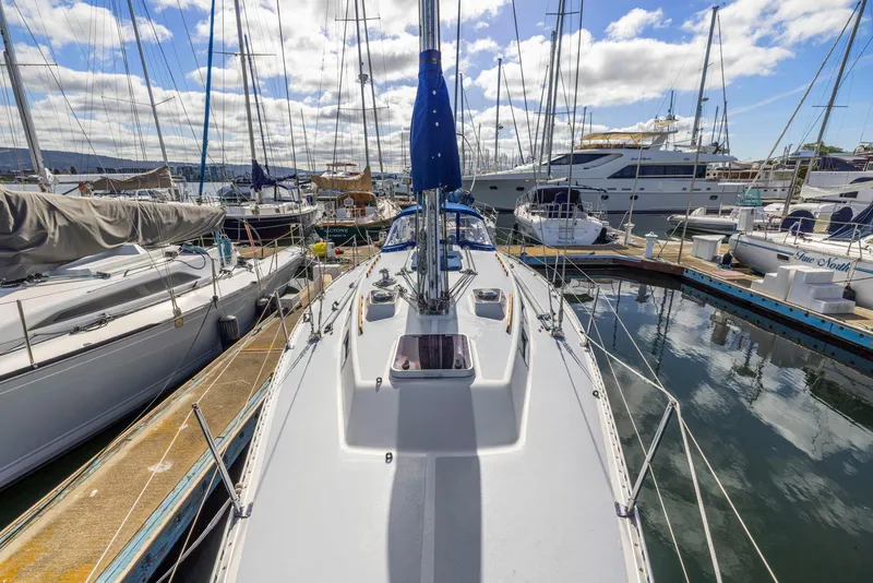 Slide: The Image of 1986 J Boats J/40 sailboat docked in a marina, surrounded by other vessels. - 16