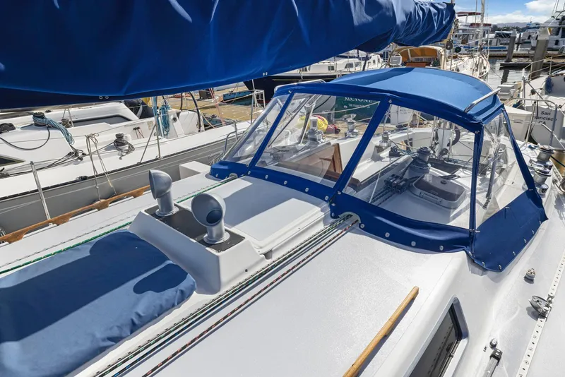 Slide: The Image of 1986 J Boats J/40 sailboat with blue canopy docked at marina. - 19