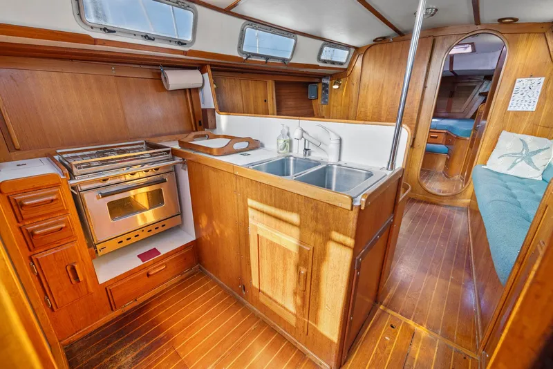 Slide: The Image of Interior of 1986 J Boats J/40 sailboat with wooden cabinetry and kitchen amenities. - 41