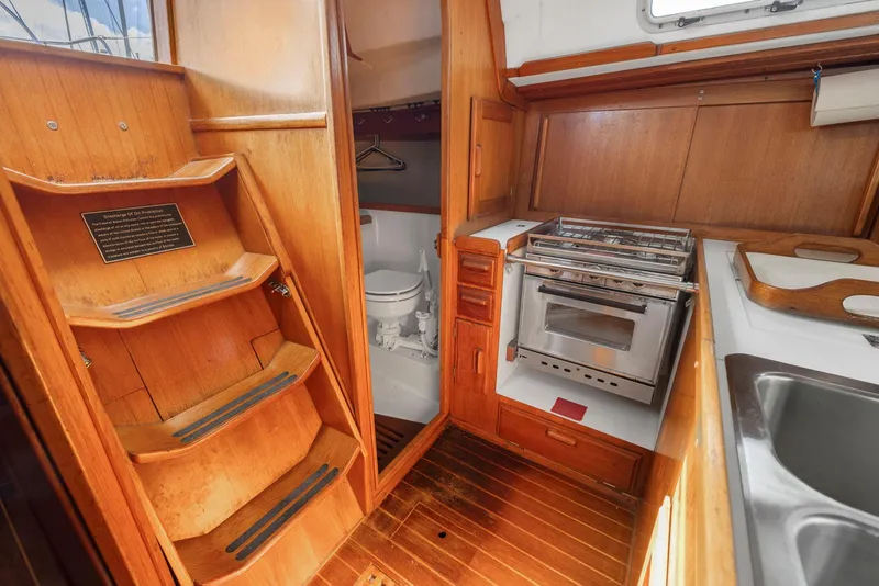 Slide: The Image of Interior of 1986 J Boats J/40 sailboat with wooden cabinetry, stove, and compact bathroom. - 42