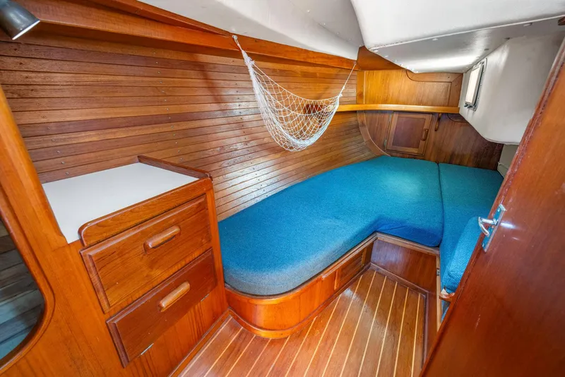Slide: The Image of 1986 J Boats J/40 cabin interior with wooden finish and blue cushions. - 44