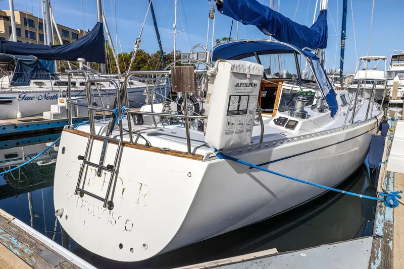 Slide: The Image of 1986 J Boats J/40 sailboat docked in marina, featuring blue sail covers and white hull. - 8
