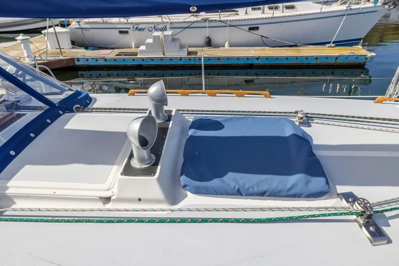 Slide: The Image of 1986 J Boats J/40 deck with blue cover and ventilation, docked at marina. - 9