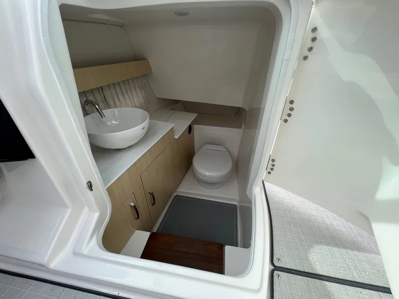 Slide: The Image of 2025 Regal 3300 boat interior bathroom with modern sink and toilet. - 13
