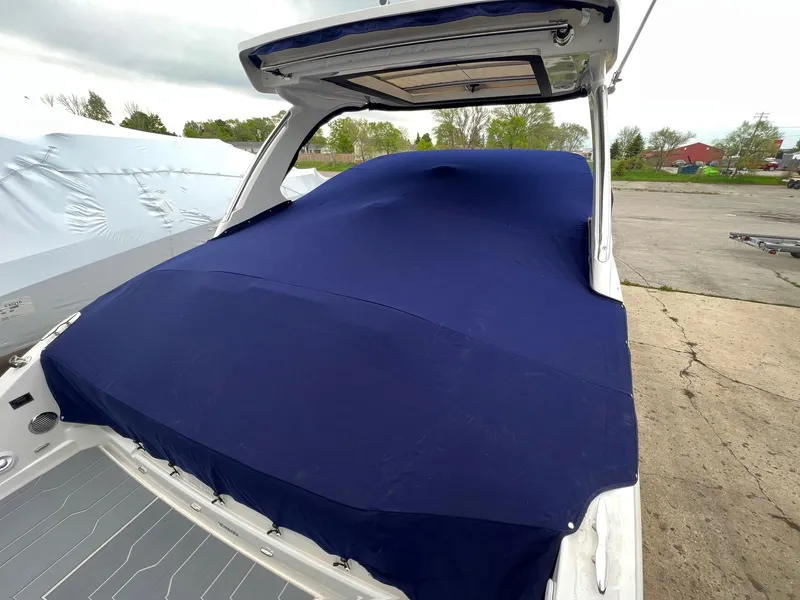 Slide: The Image of 2025 Regal 3300 boat covered with a blue tarp in an outdoor setting. - 18