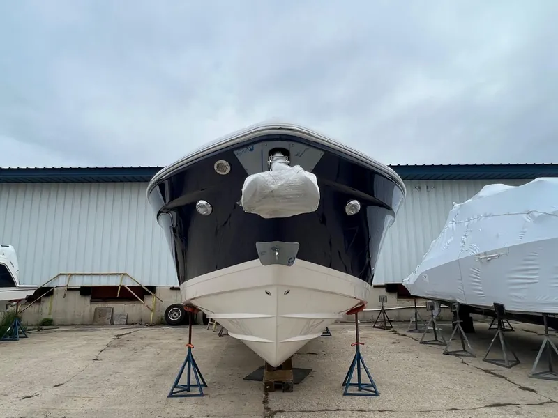 Slide: The Image of 2025 Regal 3300 boat on stands, front view, in a storage area. - 3