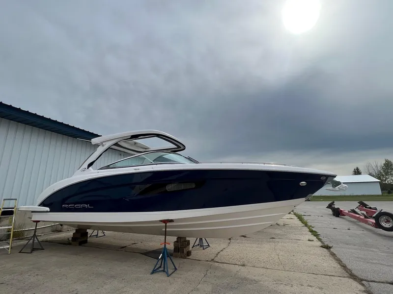 Slide: The Image of 2025 Regal 3300 boat on stands, overcast sky, outdoor setting. - 7