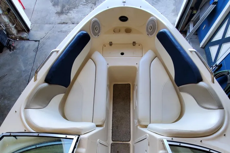 Slide: The Image of 2000 Rinker 212 Captiva boat interior with beige and blue seating. - 3