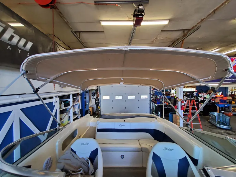 Slide: The Image of 2000 Rinker 212 Captiva boat interior with canopy in a garage setting. - 6