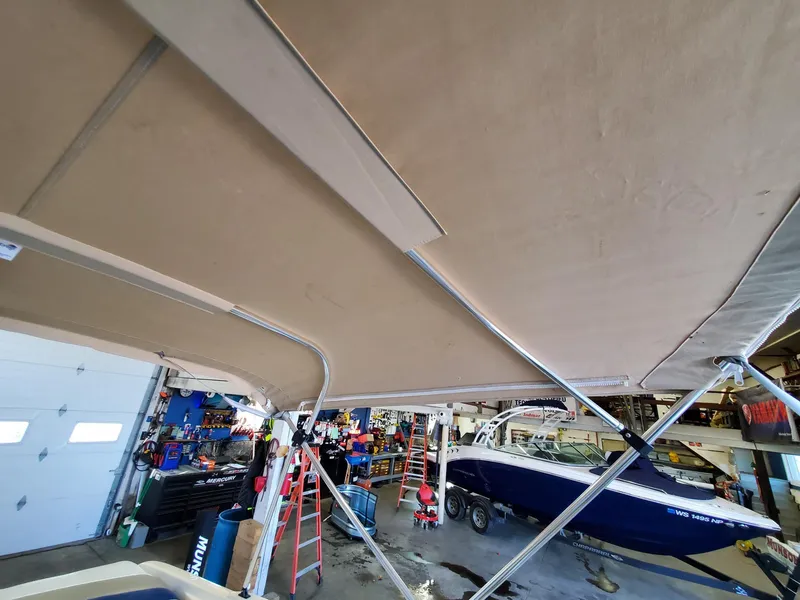 Slide: The Image of Boat maintenance in garage with Rinker 212 Captiva, 2000 model, under beige canopy. - 7