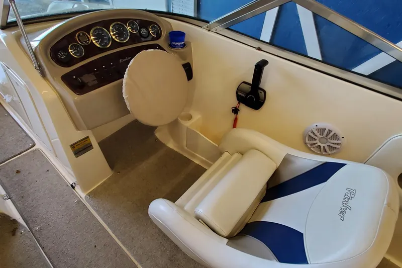 Slide: The Image of Interior view of 2000 Rinker 212 Captiva boat showing steering wheel and seating. - 8