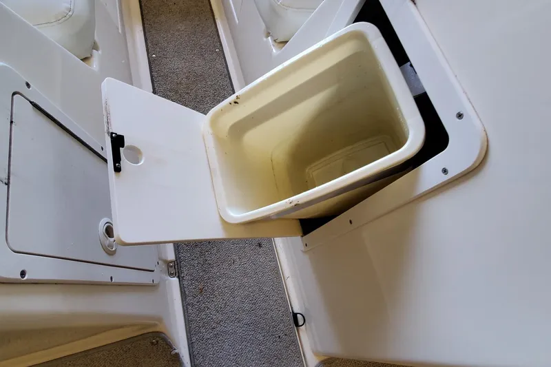 Slide: The Image of Open storage compartment on 2000 Rinker 212 Captiva boat with built-in bin. - 9