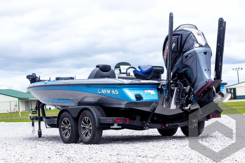 Slide: The Image of 2025 Caymas CX 20 PRO boat on trailer, blue and black design, parked outdoors. - 16