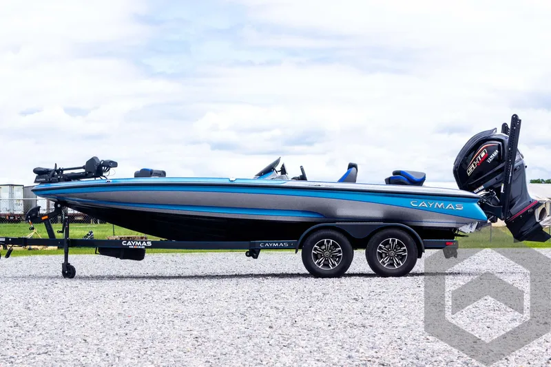 Slide: The Image of 2025 Caymas CX 20 PRO boat on trailer, blue and black design, parked on gravel. - 17