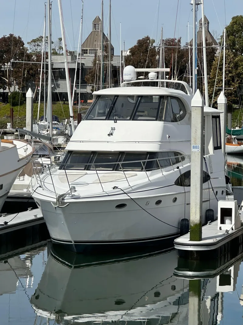 Slide: The Image of 2000 Carver 506 Motor Yacht docked in a marina, surrounded by other boats. - 1