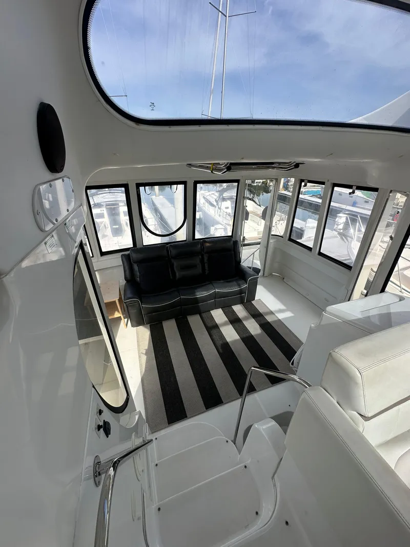 Slide: The Image of Interior of 2000 Carver 506 Motor Yacht with black sofa and striped rug. - 10