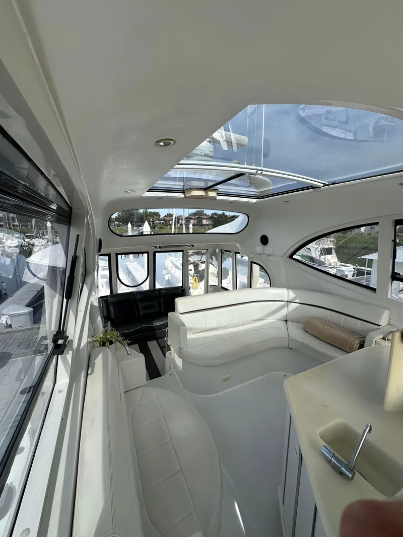 Slide: The Image of Interior of 2000 Carver 506 Motor Yacht with white seating and panoramic windows. - 11