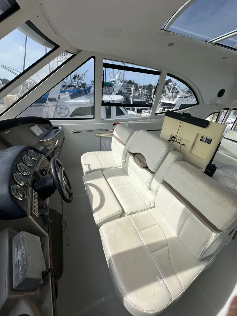 Slide: The Image of Interior of a 2000 Carver 506 Motor Yacht with white seating and control panel. - 12