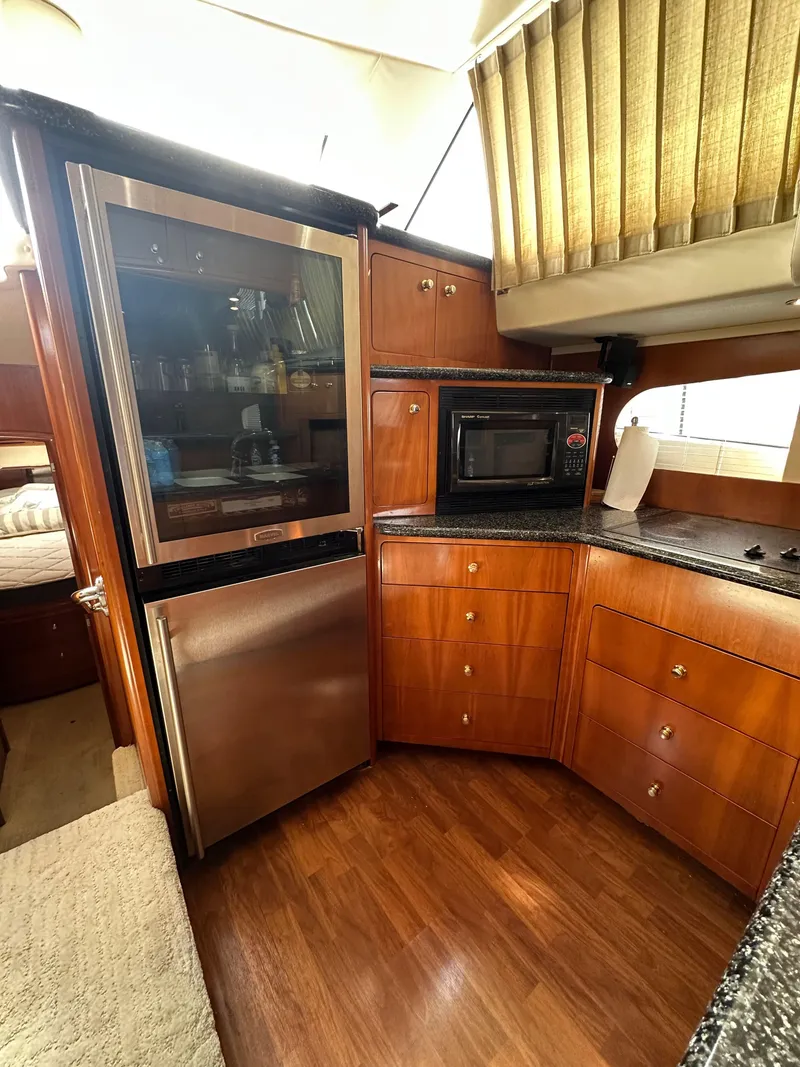 Slide: The Image of Interior of 2000 Carver 506 Motor Yacht kitchen with wood cabinetry and modern appliances. - 23
