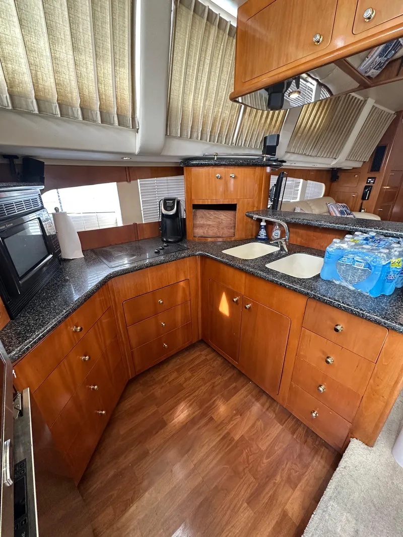 Slide: The Image of 2000 Carver 506 Motor Yacht kitchen with wood cabinets, granite countertops, and modern appliances. - 24
