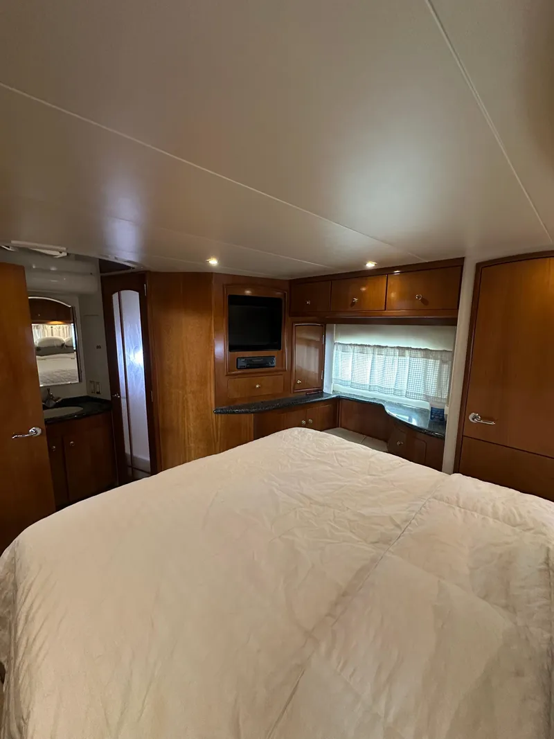 Slide: The Image of Interior of 2000 Carver 506 Motor Yacht bedroom with wood cabinetry and cozy bedding. - 27