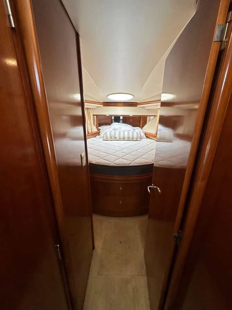Slide: The Image of 2000 Carver 506 Motor Yacht interior cabin with cozy bed and wooden finish. - 33