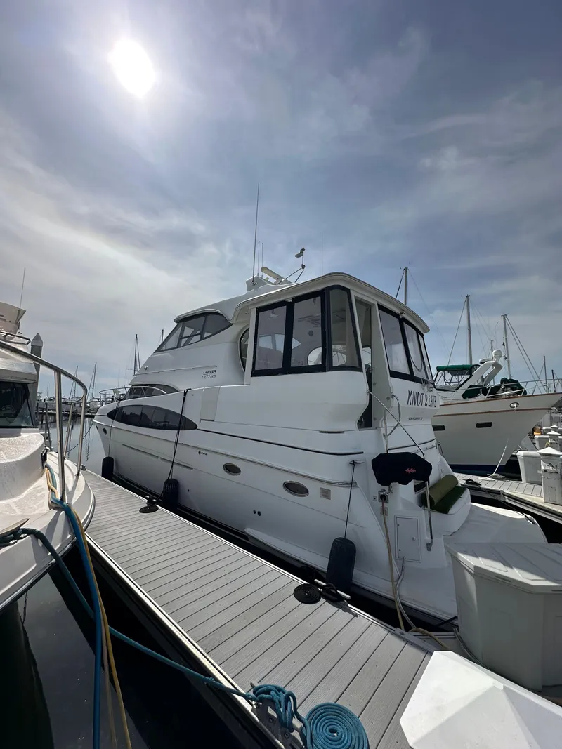 Slide: The Image of 2000 Carver 506 Motor Yacht docked under a sunny sky. - 4