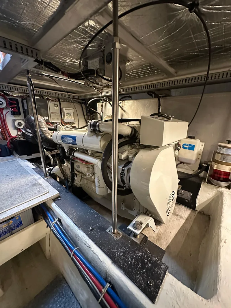 Slide: The Image of Engine room of a 2000 Carver 506 Motor Yacht, showcasing mechanical components and wiring. - 43