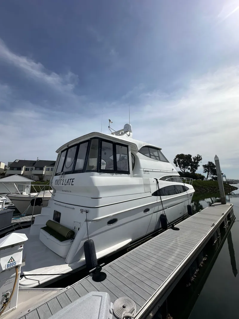 Slide: The Image of 2000 Carver 506 Motor Yacht docked under a partly cloudy sky. - 5