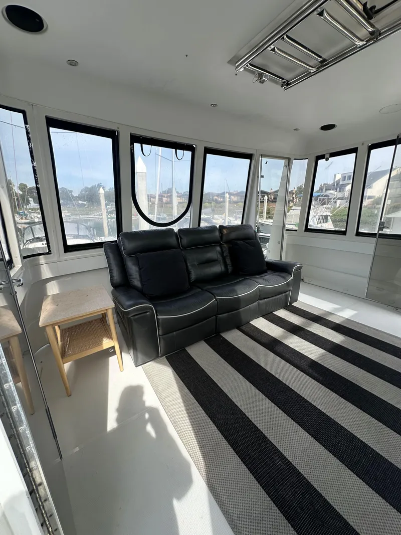 Slide: The Image of Interior of 2000 Carver 506 Motor Yacht with black sofa and striped rug. - 8