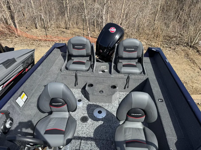 Slide: The Image of 2025 Tracker Pro Guide V-175 Combo boat interior with seating and motor, outdoors. - 9