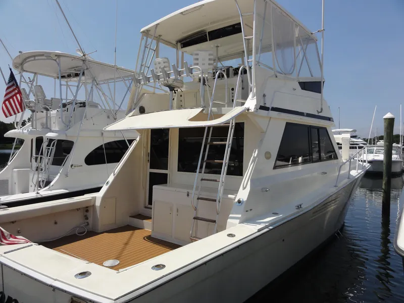 Slide: The Image of 1990 Viking 45 Convertible yacht docked at marina, featuring spacious deck and flybridge. - 1