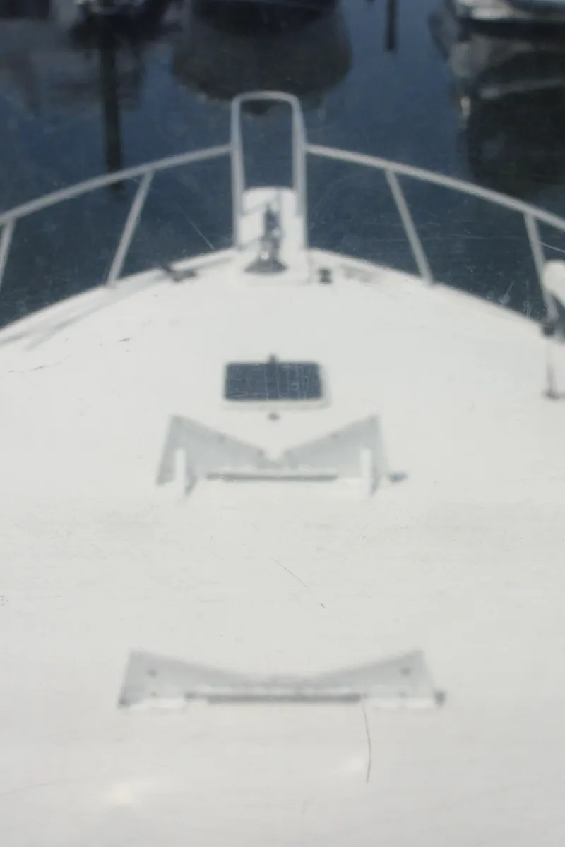 Slide: The Image of Bow view of a 1990 Viking 45 Convertible yacht at a marina. - 12