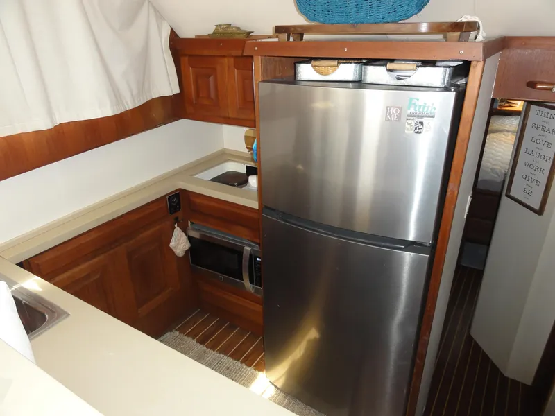 Slide: The Image of 1990 Viking 45 Convertible yacht kitchen with stainless steel fridge and wooden cabinetry. - 18