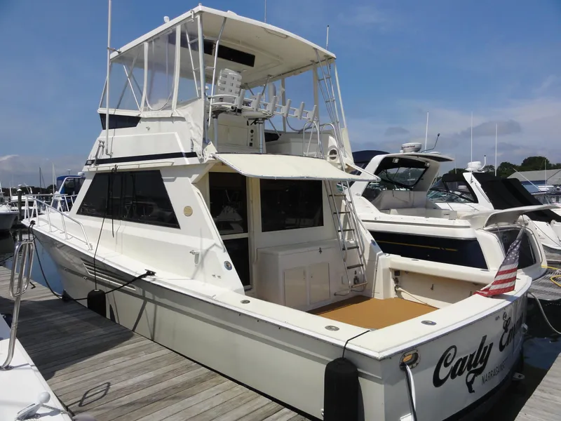 Slide: The Image of 1990 Viking 45 Convertible yacht docked at marina, featuring spacious deck and flybridge. - 2