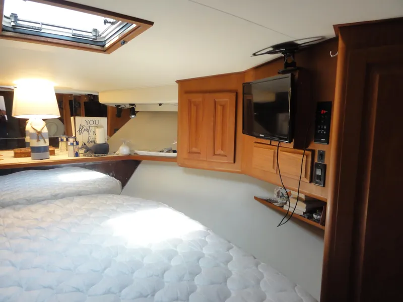 Slide: The Image of Cozy interior of 1990 Viking 45 Convertible yacht with bed, TV, and lamp. - 21