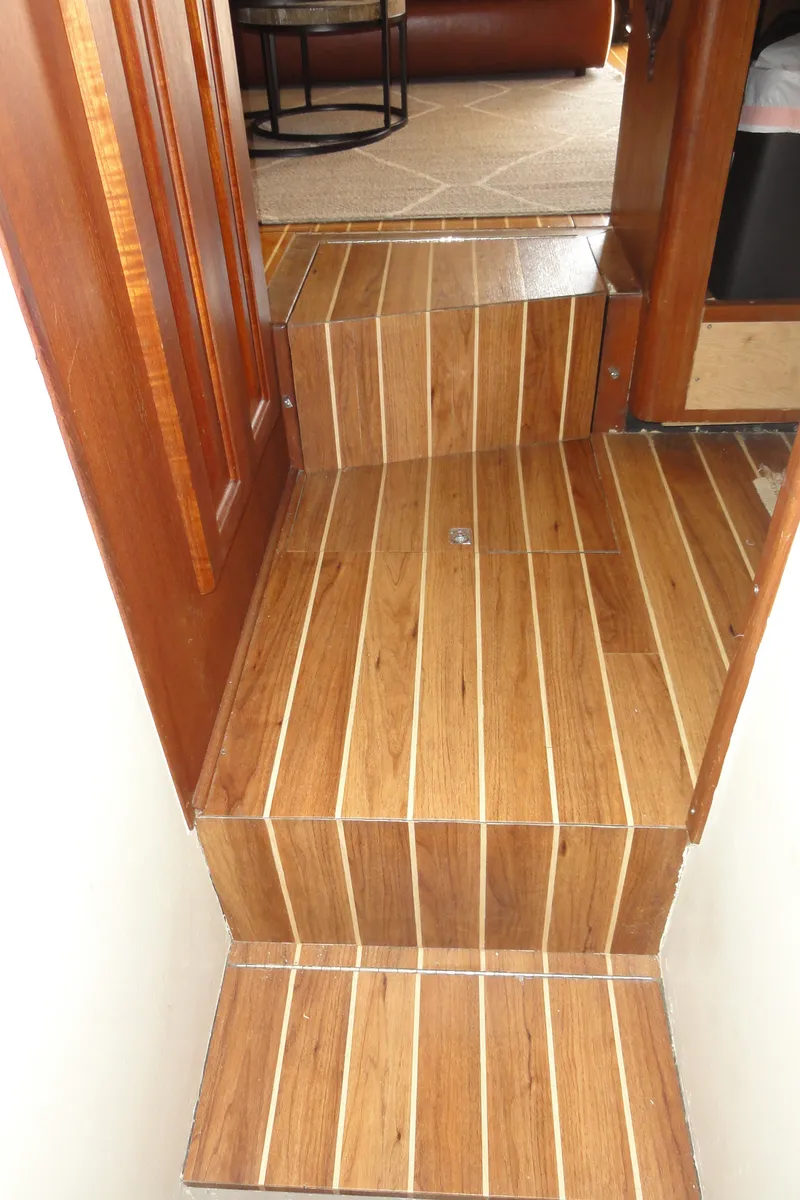 Slide: The Image of Wooden steps inside a 1990 Viking 45 Convertible yacht, leading to a carpeted area. - 26