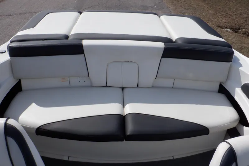 Slide: The Image of 2012 Sea Ray 205 Sport boat interior with white and black cushioned seating. - 14