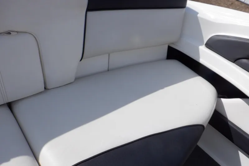 Slide: The Image of 2012 Sea Ray 205 Sport boat interior seating, featuring white and black upholstery. - 15
