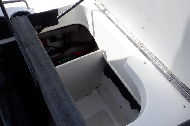 Slide: The Image of 2012 Sea Ray 205 Sport boat storage compartment with open lid and visible interior. - 21