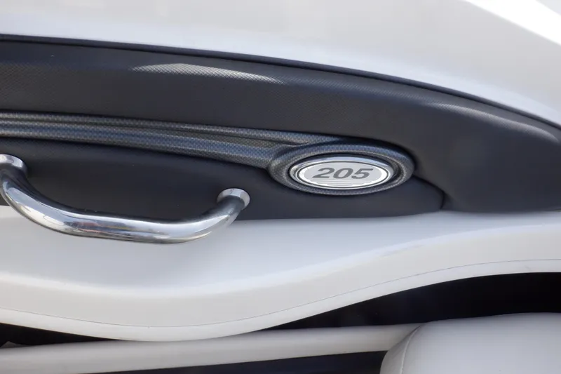 Slide: The Image of 2012 Sea Ray 205 Sport interior detail with chrome handle and model emblem. - 29