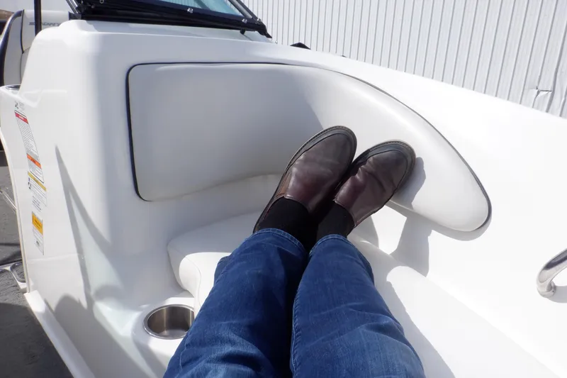 Slide: The Image of Person relaxing on a 2012 Sea Ray 205 Sport boat, feet up, wearing jeans and shoes. - 34