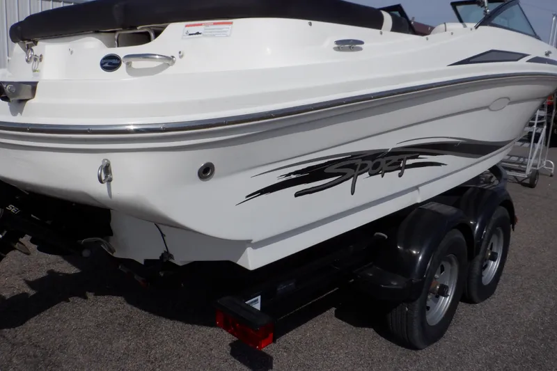 Slide: The Image of 2012 Sea Ray 205 Sport boat on trailer, rear view, white hull with "Sport" decal. - 48
