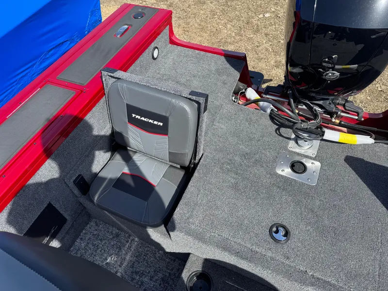 Slide: The Image of 2025 Tracker Targa V-18 Combo boat interior with seating and motor, featuring red and gray design. - 16