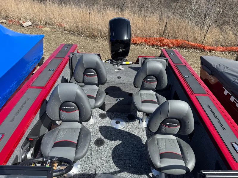 Slide: The Image of 2025 Tracker Targa V-18 Combo boat interior with four gray seats and red accents. - 17