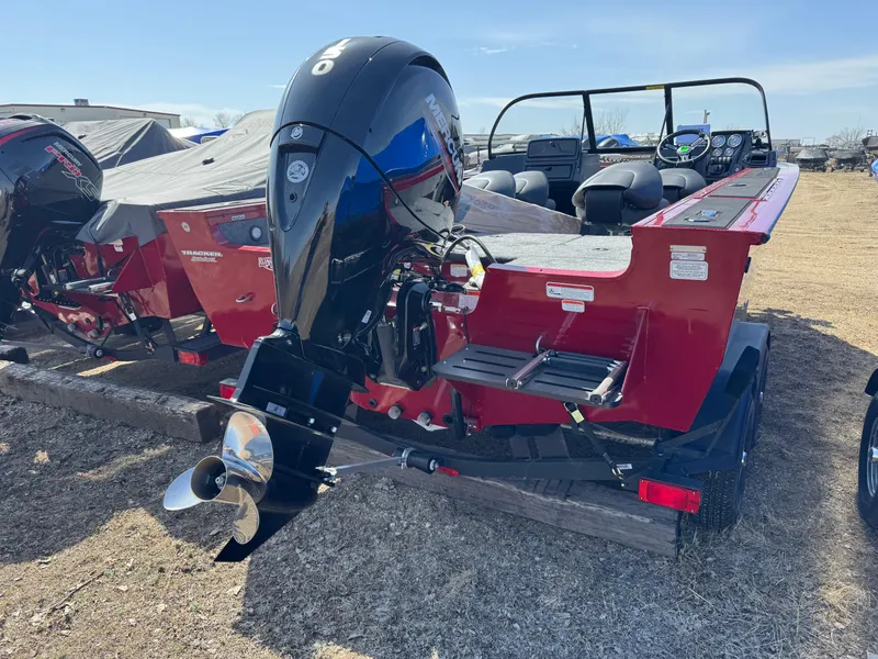 Slide: The Image of 2025 Tracker Targa V-18 Combo boat with powerful outboard motor, parked on a trailer. - 2