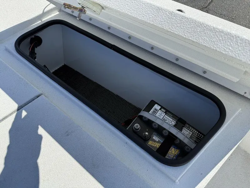 Slide: The Image of Open storage compartment in 2022 Avid 19 FS boat, showing battery placement. - 13