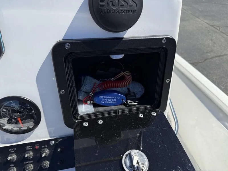 Slide: The Image of Console storage compartment in a 2022 Avid 19 FS boat with Boss audio system. - 23
