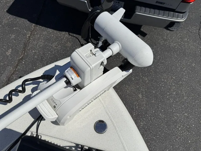 Slide: The Image of Trolling motor mounted on a 2022 Avid 19 FS boat, parked on asphalt. - 8