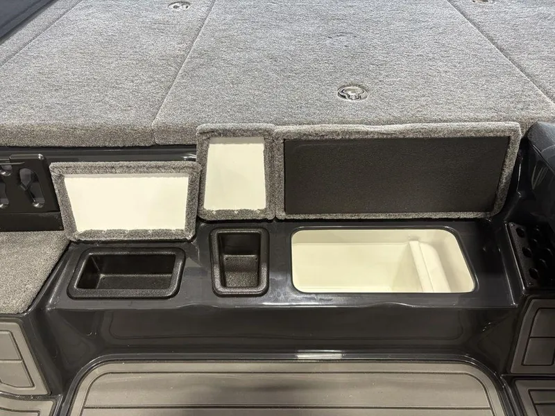 Slide: The Image of 2025 Phoenix 721 ZXL boat storage compartments with carpeted lids and organized interior spaces. - 16